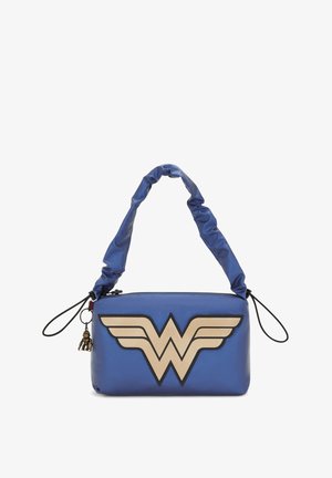 Blå faux läderhandväska med ett guld Wonder Woman-emblem och vingdesign. Har ett samlat handtag och en liten charmdetalj.