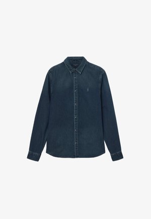 Sötét farmer gombos ing, hegyes gallérral, hosszú ujjakkal és kontrasztos varrással; kis logó található a mellkason.