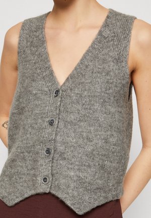 Grijze mouwloze vest van zacht materiaal, met een diepe V-hals, vijf donkere knopen en een puntige zoomdesign met een gestructureerde afwerking.