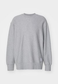 Jasnoszara bluza wykonana z miękkiego materiału. Posiada okrągły dekolt, długie rękawy, obniżone ramiona oraz małą naszywkę na dolnym końcu.