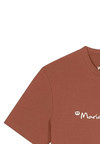 T-shirt de couleur rouille avec des manches courtes et un col rond, arborant un motif imprimé blanc sur le devant. Texture de tissu douce.