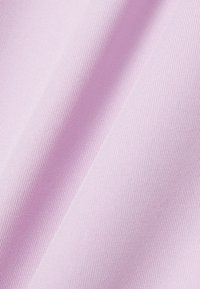 Tela de color púrpura claro con textura fina tejida, mostrada en pliegues suaves que crean sombras y reflejos delicados.