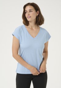 T-shirt bleu clair à manches courtes et col en V, fabriqué en tissu doux, offrant une coupe décontractée et une texture lisse. Design simple et sans ornements.