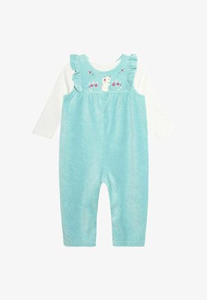 Peto de pana turquesa con tirantes en volantes, camisa blanca de manga larga debajo y detalles bordados de un ratón y flores en el cuerpo.