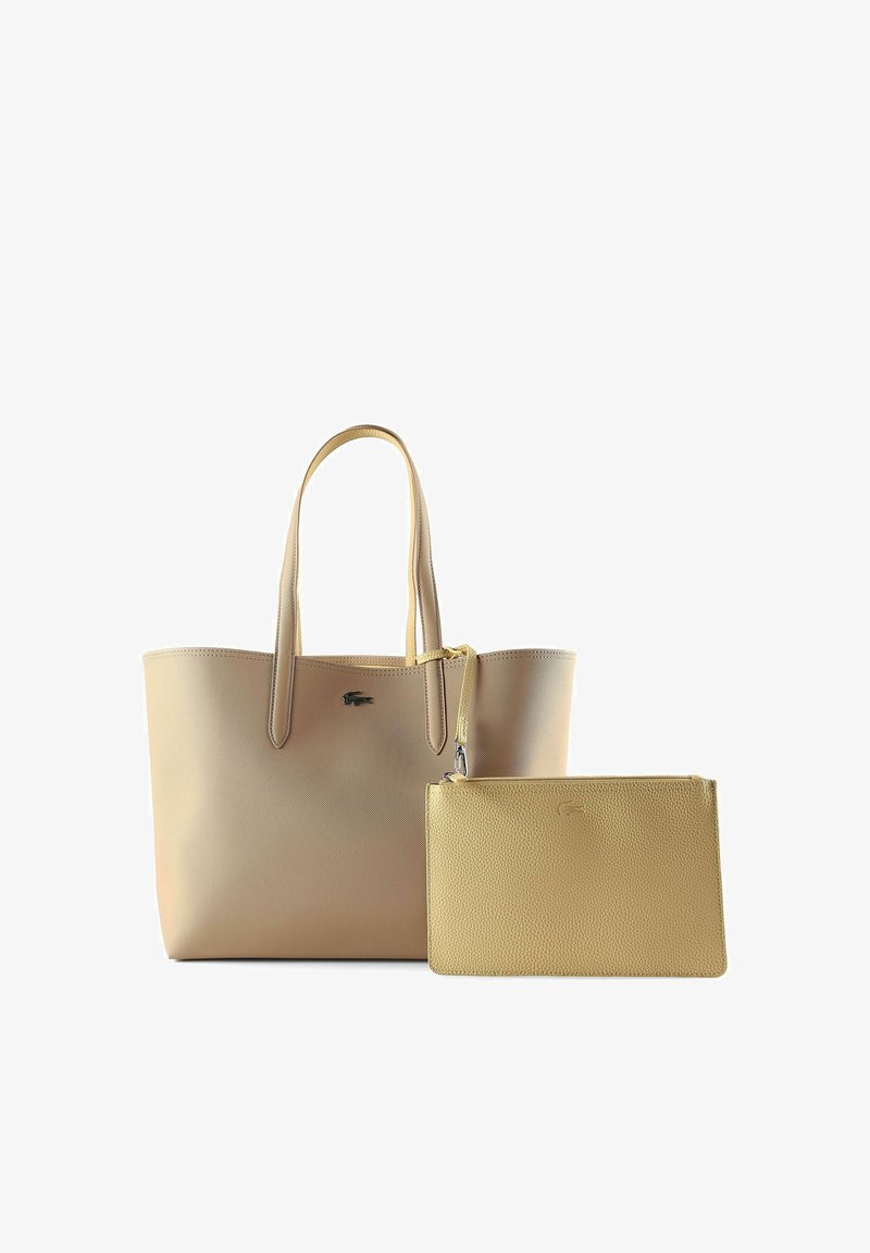 Sac cabas beige texturé avec deux poignées et une pochette jaune amovible, ornés d'un petit logo sur les deux pièces.