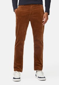 Bruine corduroy broeken met verticale strepen, rechte snit en zijzakken. Gekocht met witte sneakers met marineblauwe accenten.