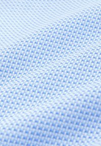 Helles blaues gewebtes Material mit einem Karomuster, das eine strukturierte Oberfläche und ein weiches, flexibles Aussehen aufweist.