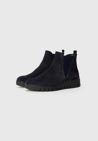 Botas de ante azul marino hasta el tobillo con paneles laterales elásticos, una suela de goma negra texturizada y un diseño de puntera redondeada. Presentan tiradores para facilitar su colocación.