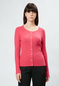 Rosa gerippter Cardigan mit langen Ärmeln, verziert mit metallischen Blumenapplikationen und einem runden Ausschnitt mit Knopfverschluss.