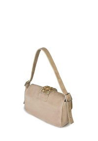 Sac à main en daim beige avec une forme arrondie, une bandoulière amovible et un fermoir décoratif orné d'accents dorés et de cristaux.