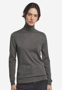 Grå polo tröja i mjukt tyg, med långa ärmar, en åtsittande design och ribbade detaljer vid kragen och fållen.