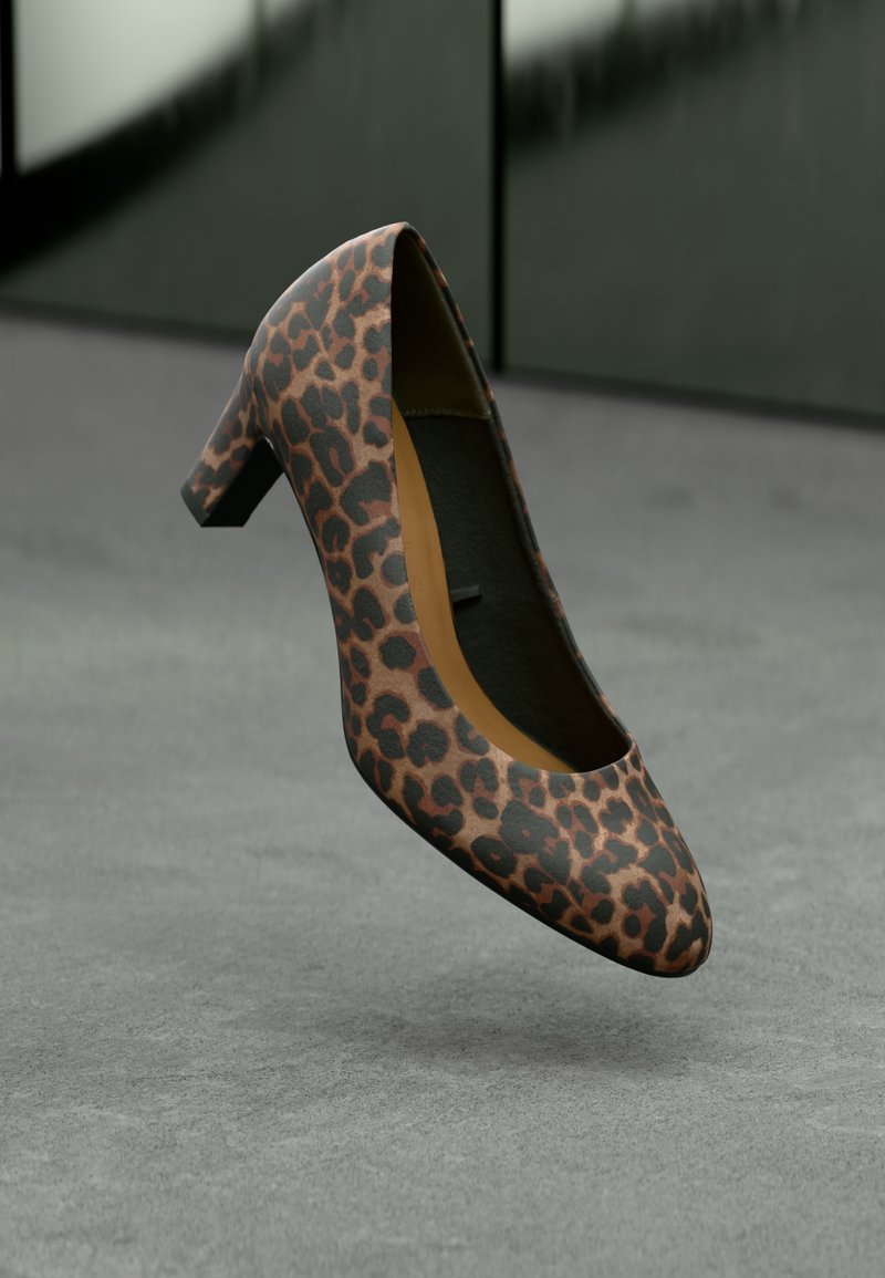 Chaussure à talon haut imprimé léopard avec un bout rond et un petit talon carré. Fabriquée en matériau texturé avec des accents marron et noirs.