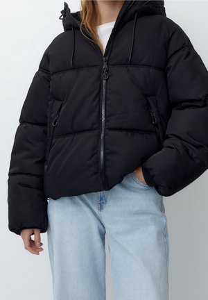 Černá péřová bunda s polstrovaným designem, kapucí a dvěma bočními kapsami na zip. Materiál je hladký a lehký, s krátkým střihem.