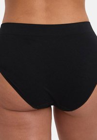 Zwarte hoge taille slip gemaakt van glad, elastisch materiaal. Heeft een eenvoudig ontwerp zonder zichtbare patronen of hardware.