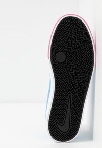 Svart gummisul med strukturerat mönster, vit mellansula och blå ovandel. Har en rosa detalj vid hälen och en Nike-logotyp.