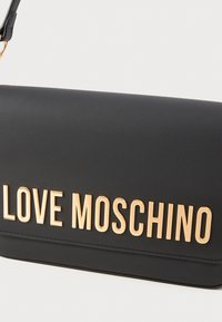 Mustmust nahk faux crossbody kott, millel on tõstetud kuldne "LOVE MOSCHINO" logo, sile tekstuur ja kompaktne ristkülikukujuline kuju.