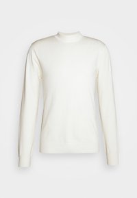 Pull en tricot blanc uni à manches longues avec un col rond haut et des poignets et un bas-côte sur un fond clair.