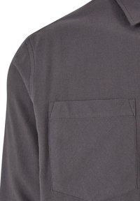 Ciemnoszara koszula z długim rękawem wykonana z teksturowanego materiału, z kieszenią na piersi i klasycznym kołnierzykiem. Szycie jest widoczne wzdłuż krawędzi.