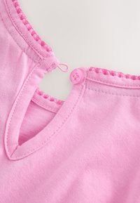 Scollo in tessuto rosa con cuciture smerlate, caratterizzato da una piccola chiusura con bottone e asola su sfondo chiaro.