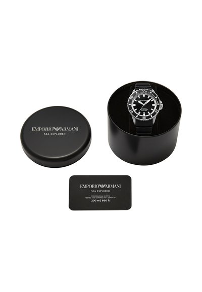 Montre de plongée Emporio Armani Sea Explorer noire avec bracelet noir dans une boîte ronde noire, accompagnée d'un couvercle et d'une carte de certification.