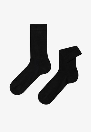 Schwarze Baumwollsocken mit glatter Textur, ausgestattet mit einem standardmäßigen Bündchen-Design und verstärktem Fersen- und Zehenbereich für Haltbarkeit.