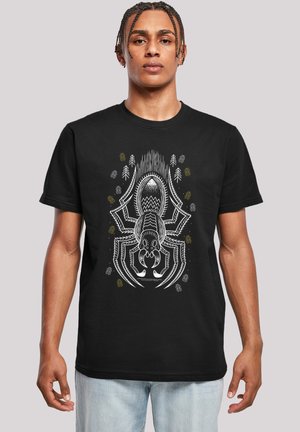 Sort t-shirt med et detaljeret hvidt og farvet edderkoppemotiv, omgivet af abstrakte mønstre og silhuetter af træer.