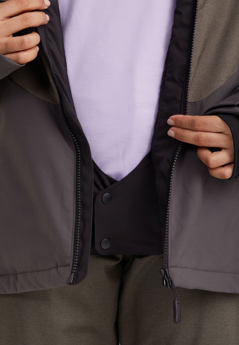 Grau und schwarze Außenjacke mit Reißverschluss, Innenklappe und Druckknöpfen. Verfügt über eine strukturierte, enganliegende Innenschicht.