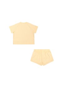 Ensemble en coton jaune clair composé d'un haut boxy à manches courtes et d'un short à taille élastique avec une coupe décontractée et une texture lisse.