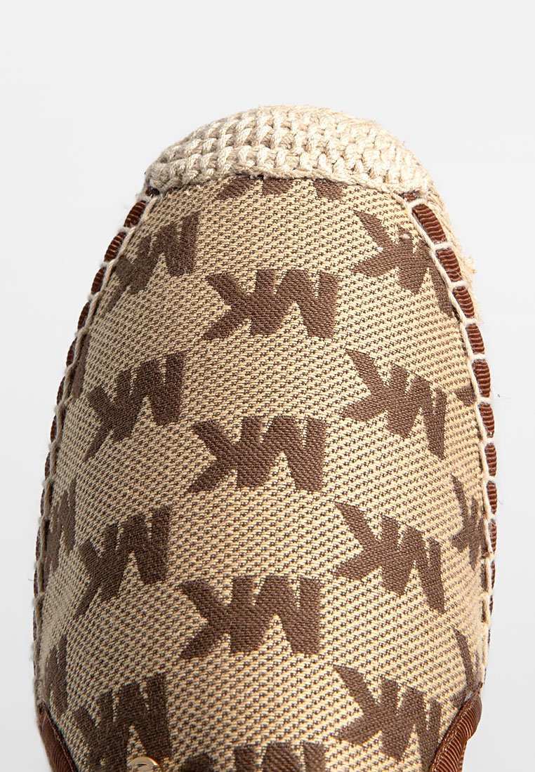 Scarpa slip-on beige con motivo, con design del logo marrone, texture intrecciata e dettagli intrecciati lungo il bordo. Parte superiore in tessuto morbido.