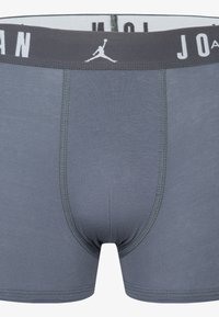 Graue Boxer-Shorts mit enger Passform. Verfügen über einen grauen elastischen Bund mit weißem "Jordan"-Schriftzug und Logo. Glatte Stoffstruktur.
