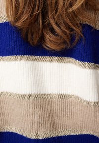 Chunky gebreide trui met brede horizontale strepen in marineblauw, crème, beige en gouden accenten, met een gestructureerde stofafwerking.