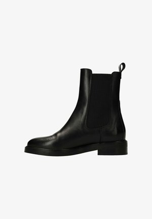 Zwarte leren Chelsea-boot met elastische zijpanelen, ronde neus en een lage blokhak. Voorzien van een trekband aan de achterkant voor gemakkelijk aan- en uittrekken.