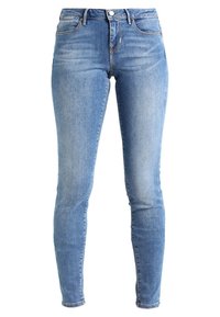 Hubené džíny z denimu. Světle modrá barva s mírným vyblednutím, design s pěti kapsami, zapínání na zip a kovový knoflík v pase.