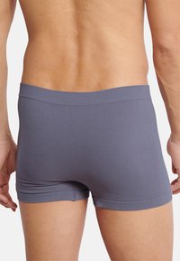 Grå boxer briefs med en glat tekstur, mid-rise talje og tætsiddende design, der viser en sømløs finish og ingen synlige logoer.