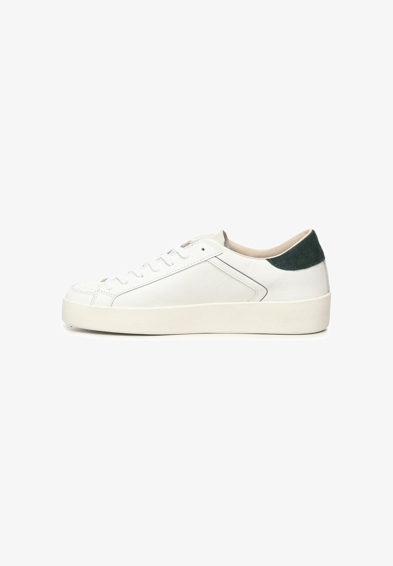 Witte leren sneaker met een groene suède hielstrook, ronde neus, platte zool en vetersluiting. Heeft een minimalistisch ontwerp en een gladde textuur.