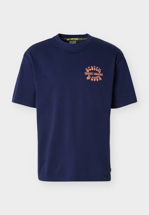 Navyblauw T-shirt met korte mouwen, ronde hals en kleine oranje tekst "Scotch Desert Solstice & Soda" op de linkerborst.