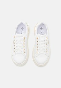 Sneaker bianche con tomaia in pelle liscia, occhielli dorati e lacci rotondi. Punta arrotondata e suola in gomma color crema. Marchio Tommy Hilfiger ben visibile.