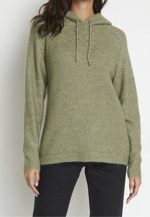 Olijfgroene gebreide hoodie met ribbels aan de mouwen en onderrand, voorzien van een trekkoord en subtiele textuur, gedragen met zwarte broek.