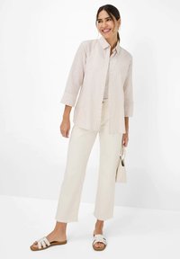 Light pink and white striped button-down shirt with three-quarter sleeves, paired with cream wide-leg pants and white slide sandals.