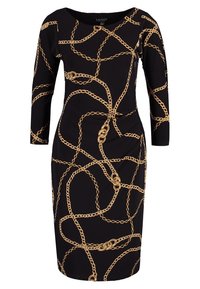 Sort kjole med en tætsiddende silhuet, der har et guld kædemønster, som omfavner kjolen, lange ærmer og en rund halsudskæring.