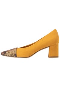 Décolleté gialla in suede con punta quadrata e tacco a blocco. La punta presenta un dettaglio in tessuto decorato, unendo texture e colori per un contrasto armonioso.