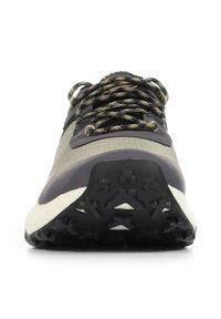 Vue de face d'une basket grise et noire avec des lacets à motifs et une semelle texturée et robuste.