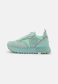 Jasnozielone sneakersy z siateczkowym i zamszowym wierzchem, grubą platformą oraz okrągłą naszywką z logo. Posiadają teksturowane akcenty i sznurowaną konstrukcję.