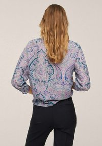 Blouse à manches longues avec un motif cachemire violet agrémenté d'accents verts et bleus. Tissu doux et léger avec une coupe décontractée et des poignets retroussés.