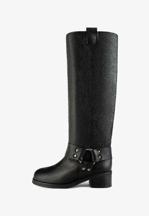 Botte noire en cuir montante jusqu'au genou avec une surface texturée, un bout arrondi et un talon épais. Dispose d'une bride à boucle et d'accents métalliques argentés.