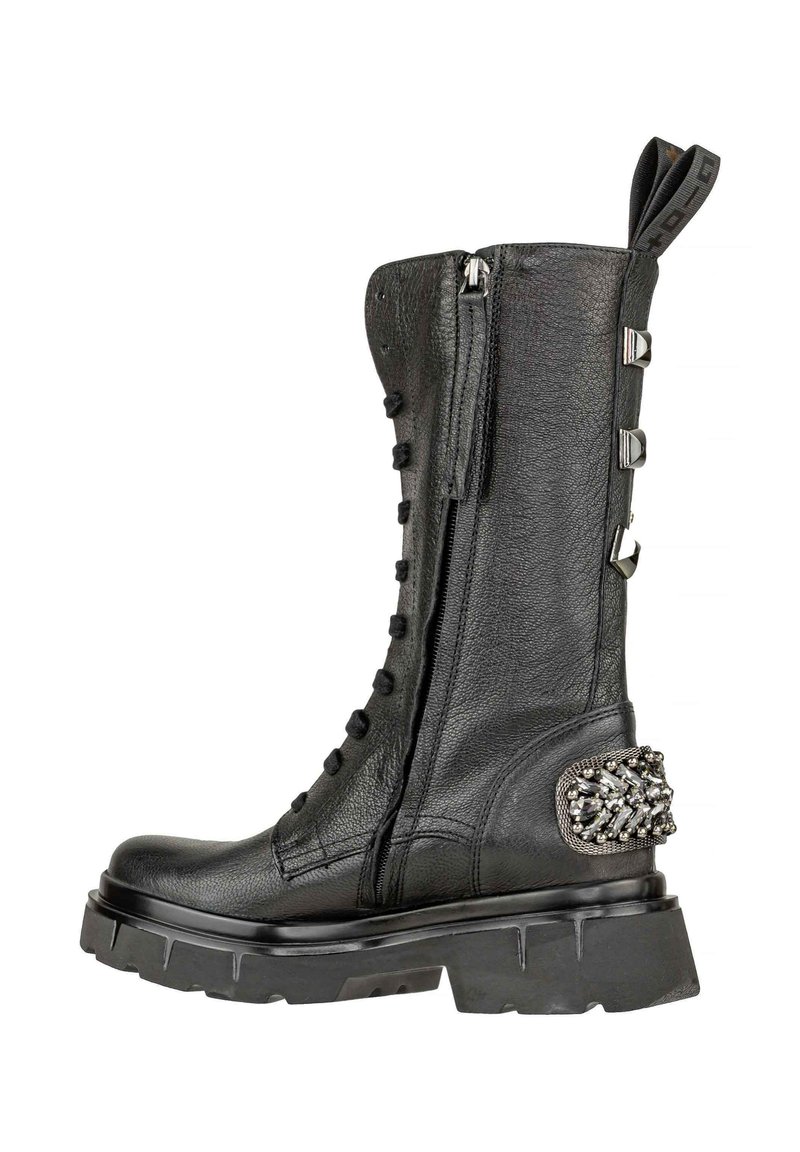 Stivale in pelle nera fino al polpaccio con cerniera laterale, lacci anteriori, suola spessa, borchie decorative sul tallone e un tassello per il sollevamento in cima.