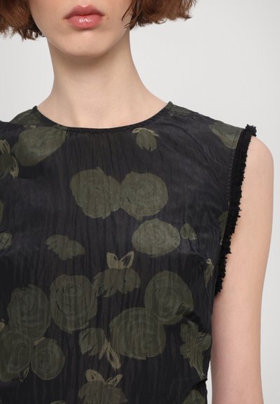 Zwarte mouwloze top met een abstract bloemenpatroon in olijfgroen. Gerimpelde randen bij de armsgaten zorgen voor textuur in de lichte stof.