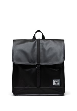 Mochila negra hecha de material duradero con solapa plegable, hebilla ajustable y un pequeño parche de marca en la parte frontal.
