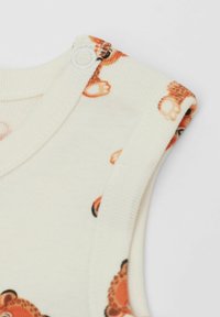 Krémově zbarvené body bez rukávů s oranžovým vzorem medvídků. Obsahuje patentky na ramenech pro snadnou manipulaci při oblékání.