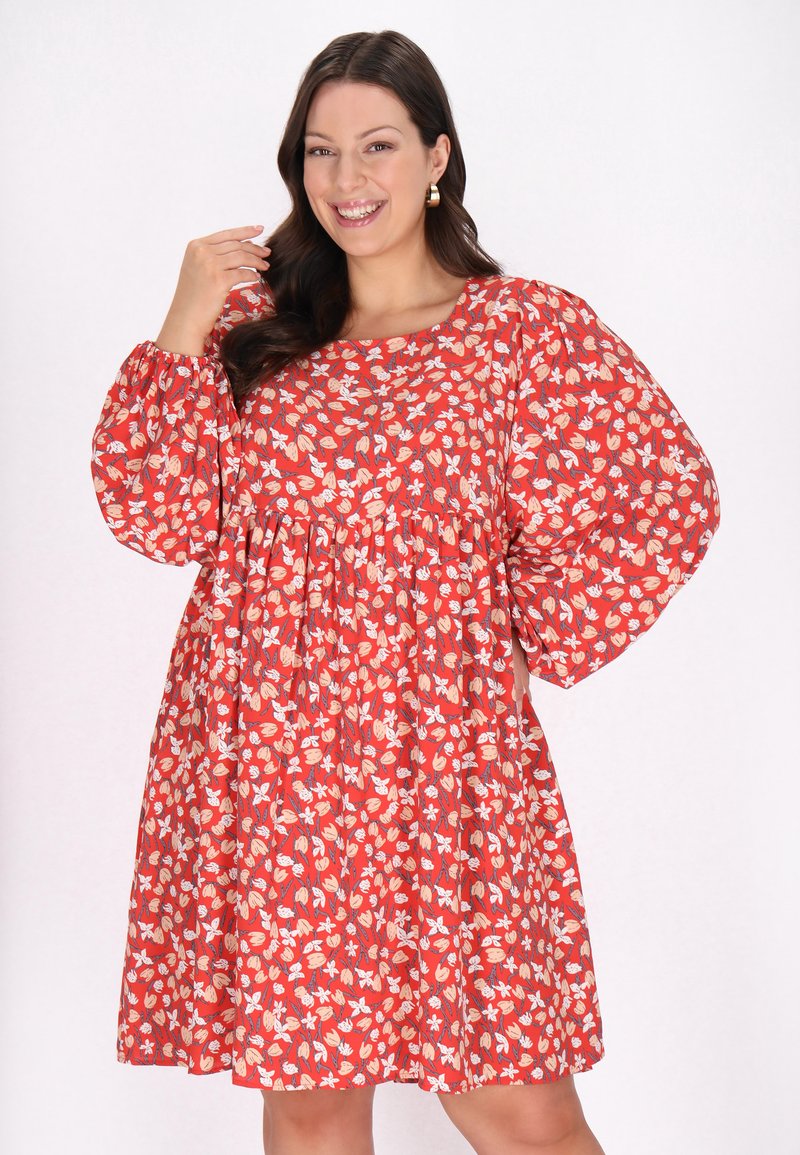 Rochie roșie cu flori, cu mâneci bufante, având o talie strânsă și o croială lejeră. Modelul include diverse flori și frunze în culori crem și pastel.
